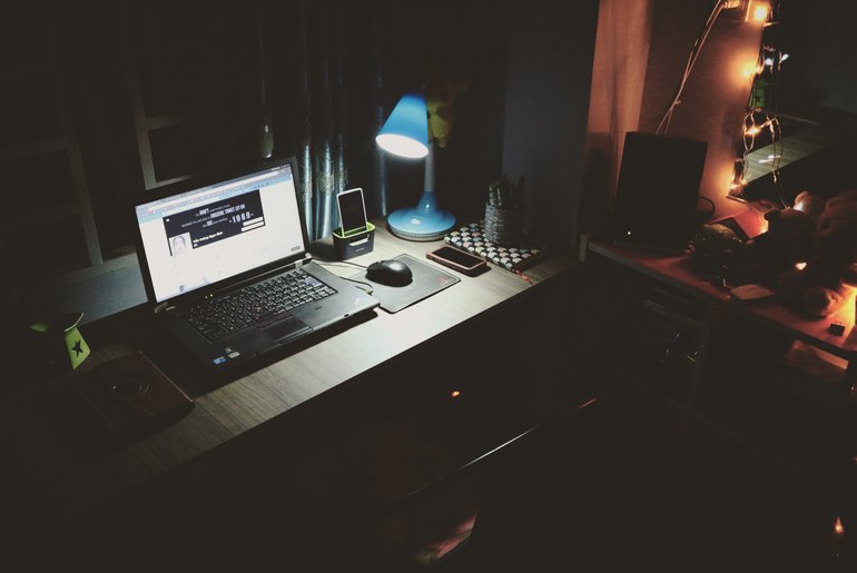 Dark office lit by desk lamp
