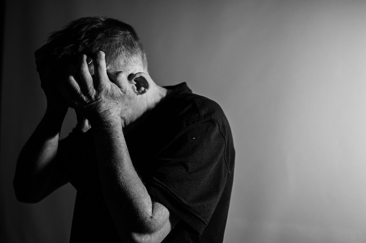 Depressed Man Holding His Head In His Hands