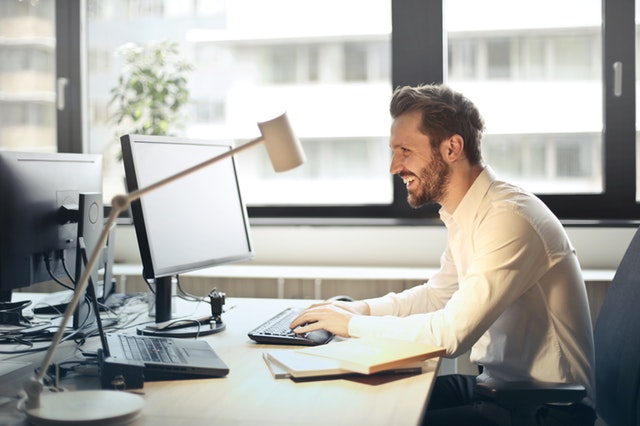 man sitting by computer laughing