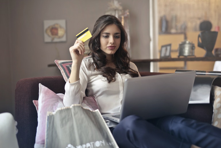 Woman with card in hand shopping online