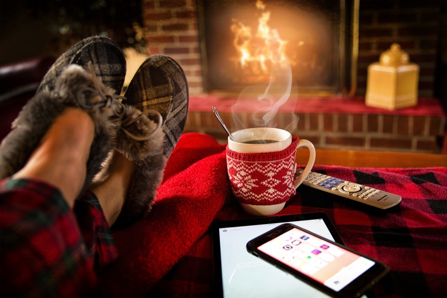 Feet In Slippers with mug of cocoa by a roaring fire