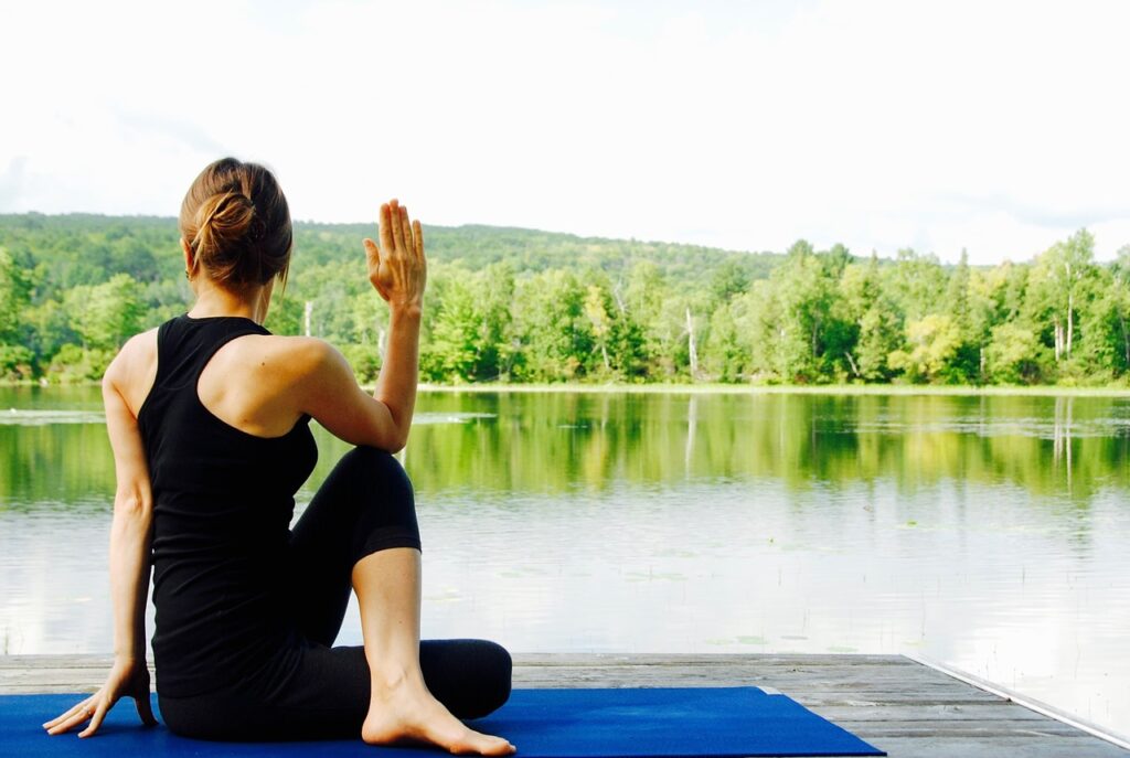 Woman practising yoga by a lake
