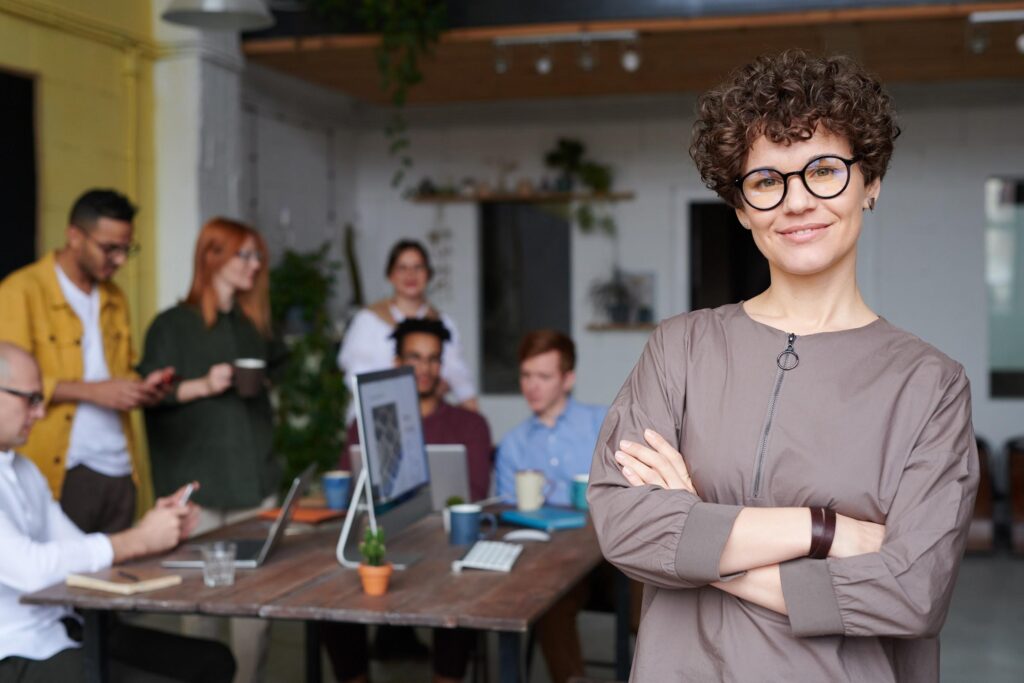 Woman smiling in front of a group of co-workers