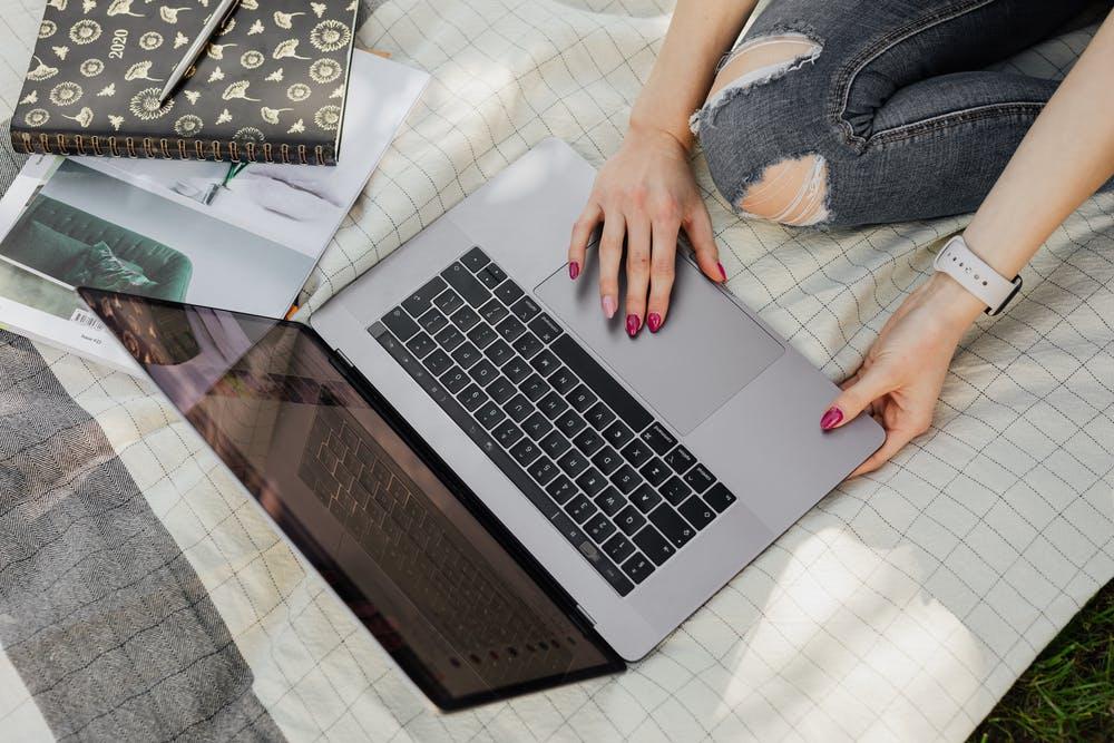 Woman using laptop on a bed