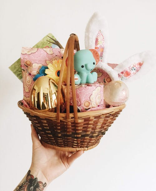 Person holding a basket of handmade gifts