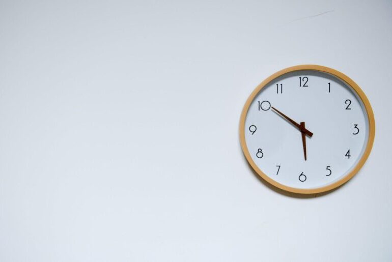 Wooden rimmed clock on grey wall