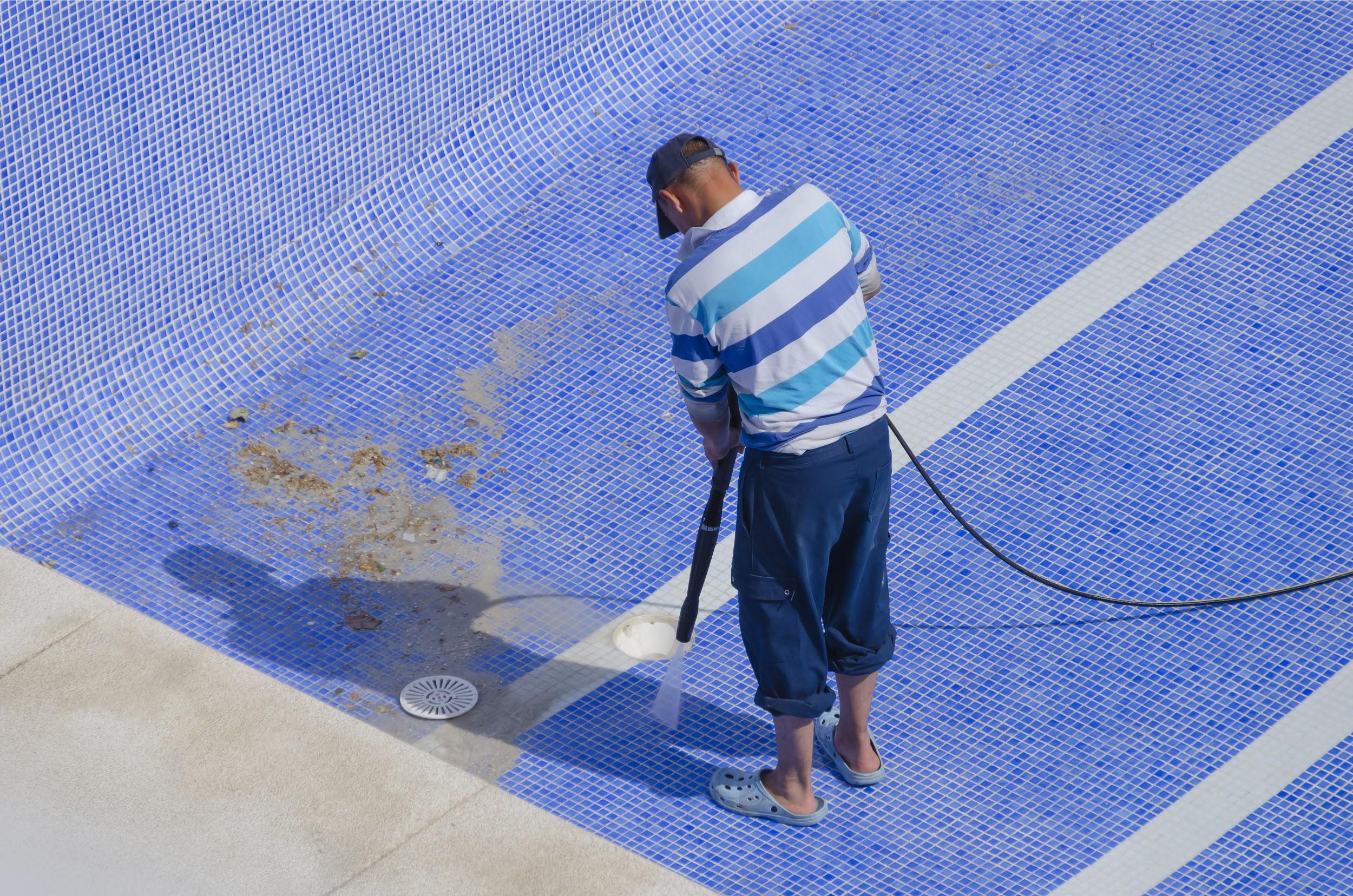Man cleaning floor of pool