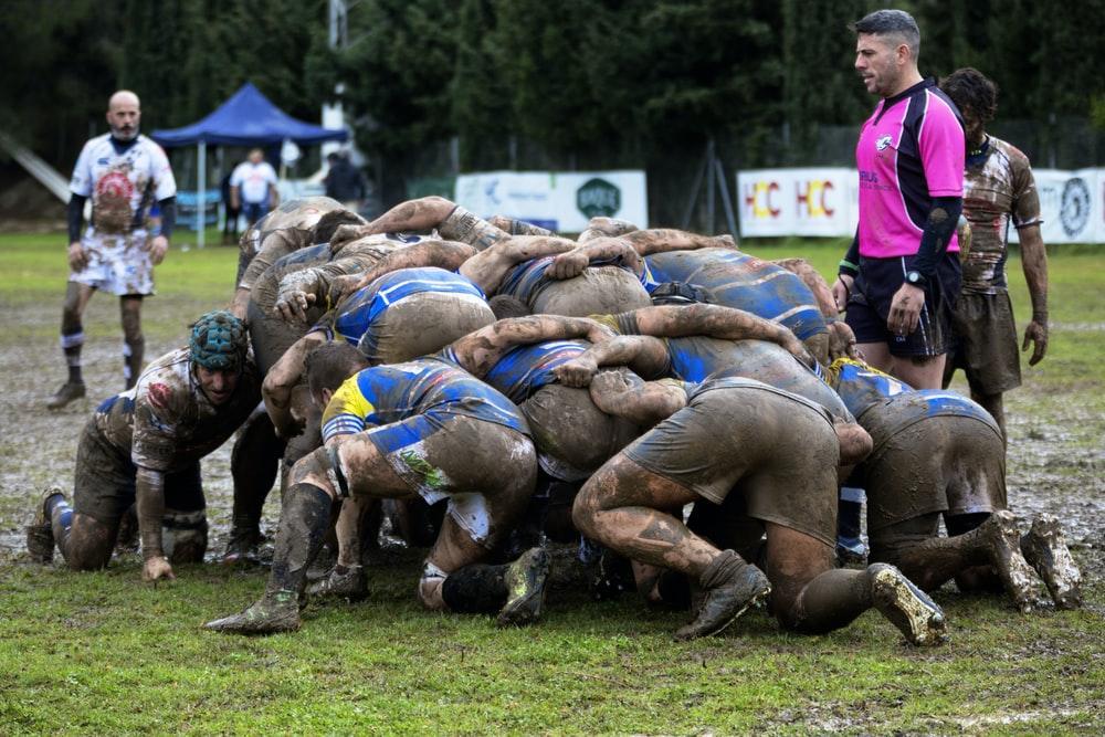 men playing rugby on mud