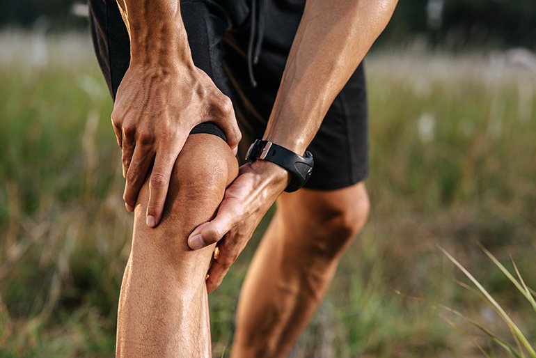 Jogger holding knee after running