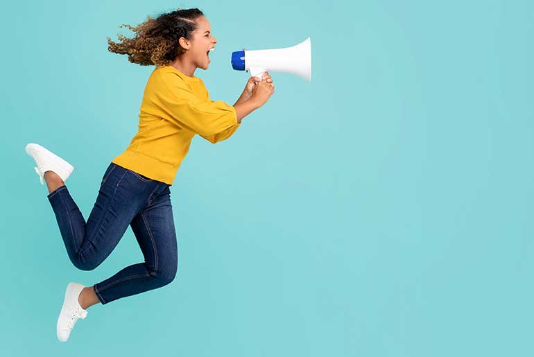 Woman jumping with megaphone