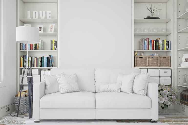 White sofa and shelves against a white wall