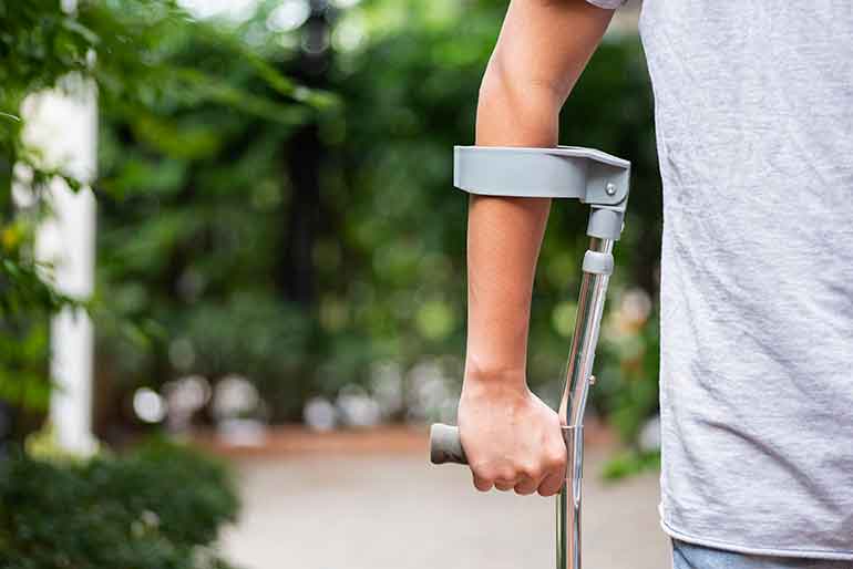 Injured man walking on crutches