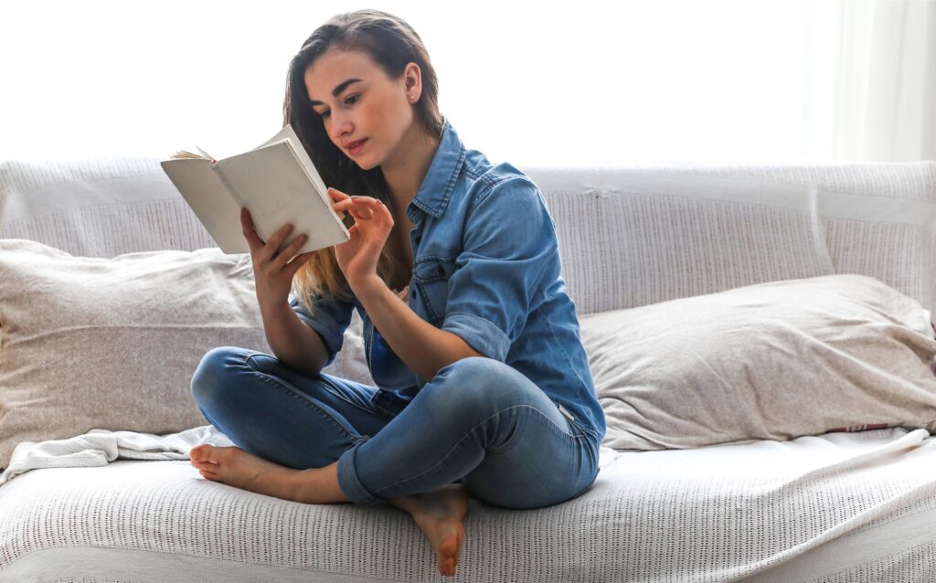 Woman sat on a sofa reading