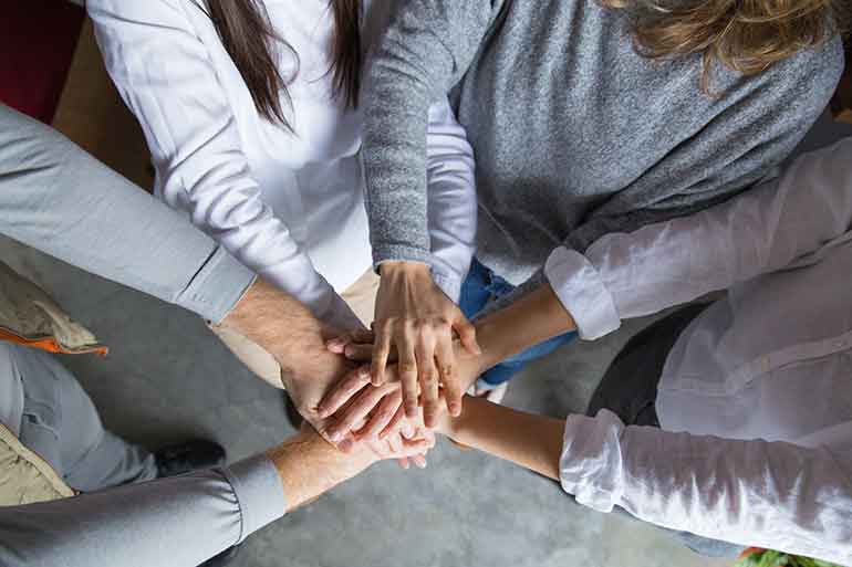 Employees joining hands together