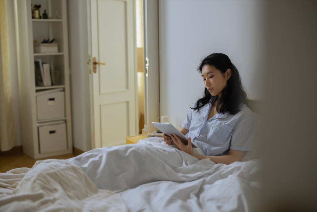 Woman in bed looking at a tablet