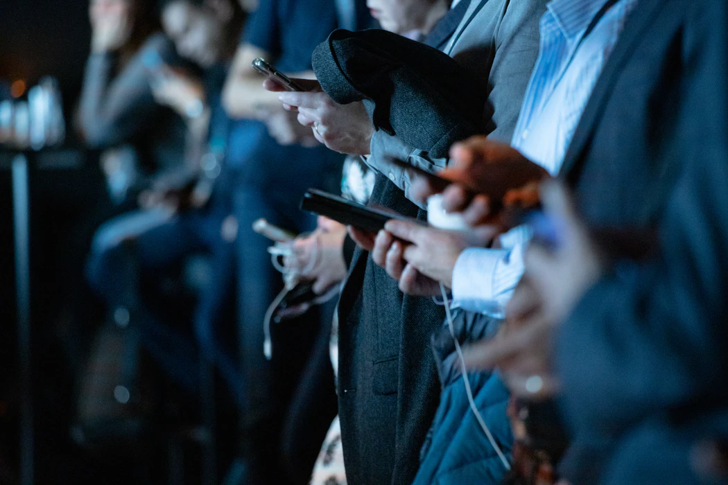 Group of people in line staring at phone