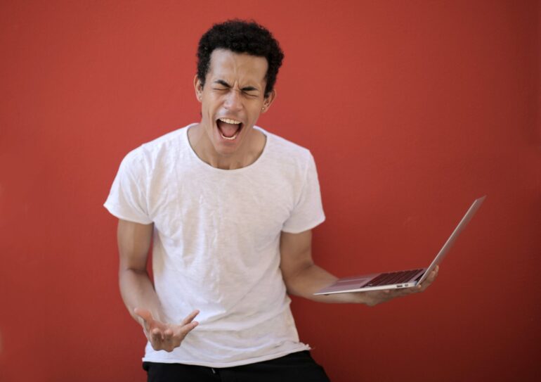 Man screaming at laptop