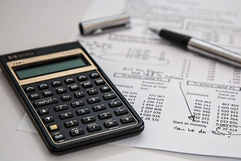 Calculator and ballpoint pen on a budget sheet