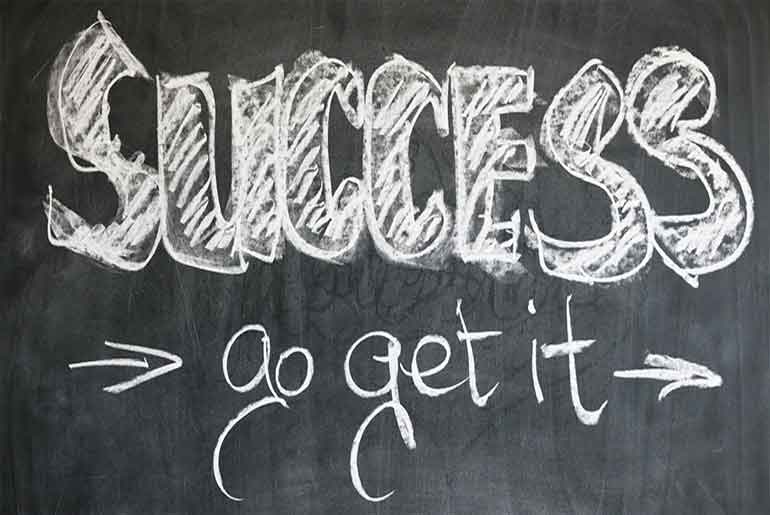 Black board with "Success Go Get It" written in chalk