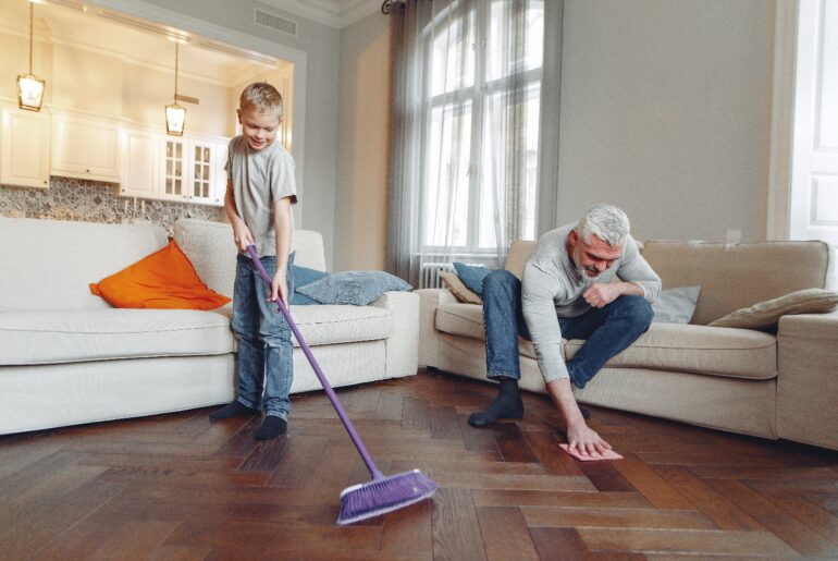 Child and man cleaning wooden floor