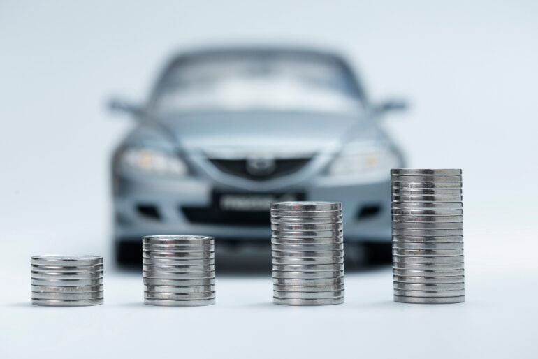 Pile of coins in front of a car