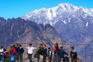 School children standing in front of a scenic mountain