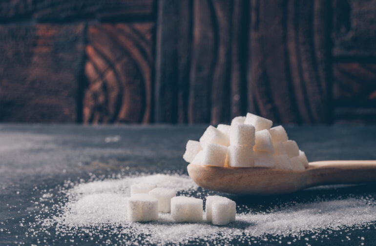 Sugar cubes piled on a wooden spoon