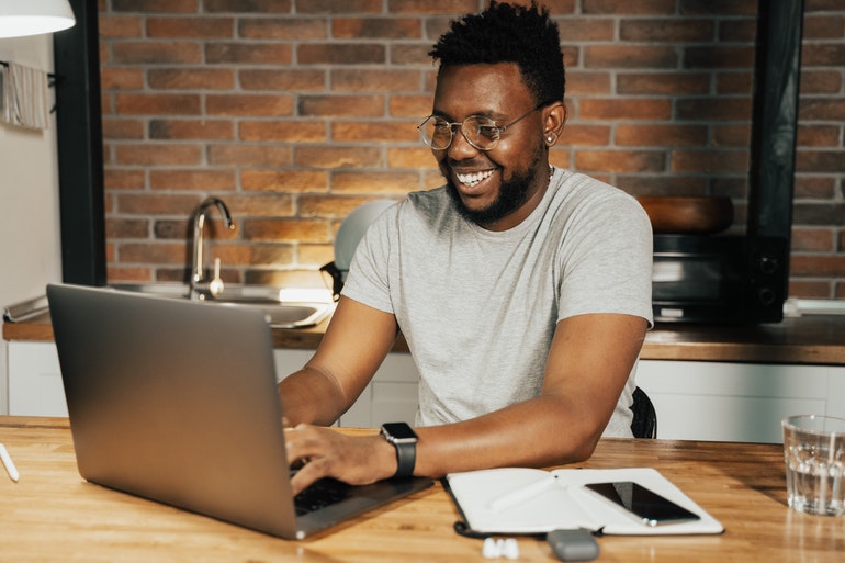 Smiling man using a laptop