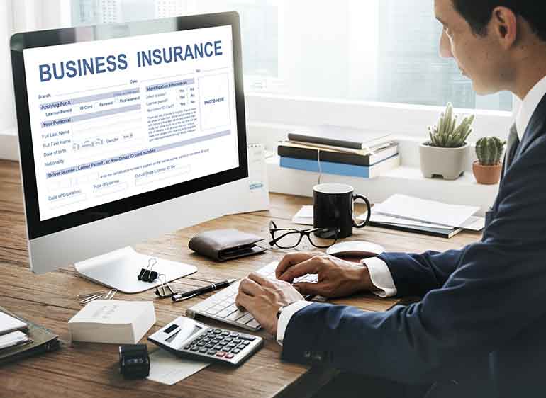 Man using an iMac with business insurance on the screen