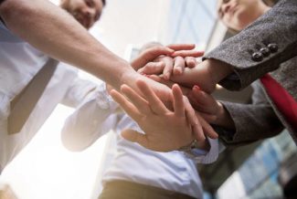 Employees holding hands in effective teamworking