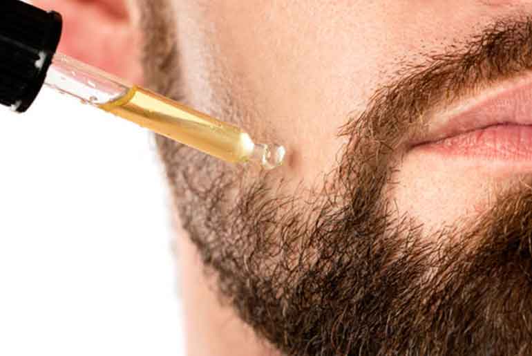 Person putting oil on their beard