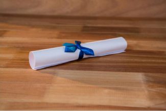 Scroll tied with blue ribbon on a wooden background