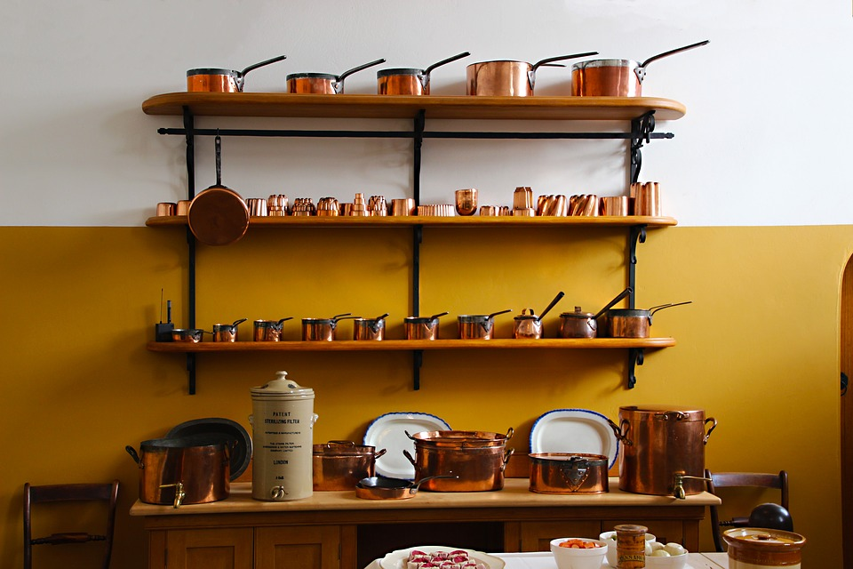 Copper pans displayed in size order on some shelves