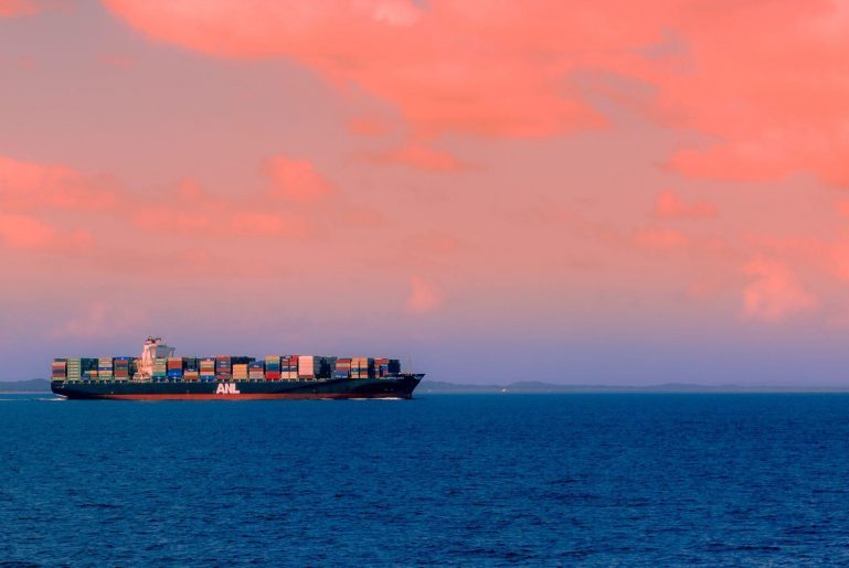 Large container ship against a pink sky