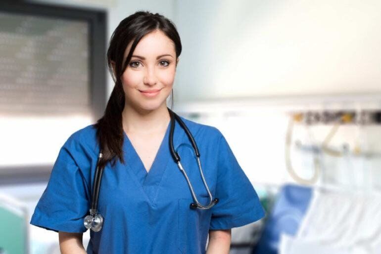 Nurse wearing blue scrubs with a stethoscope around her neck