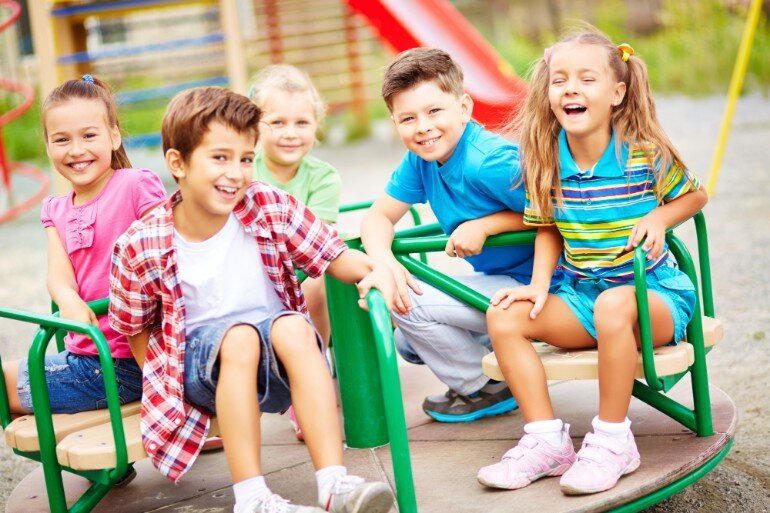 Group of smiling children outside on play equipment