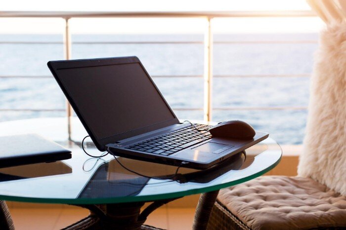 Laptop on a glass table by the ocean