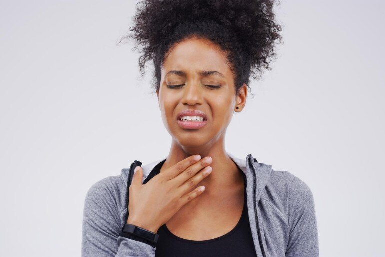 Woman holding a hand to her throat