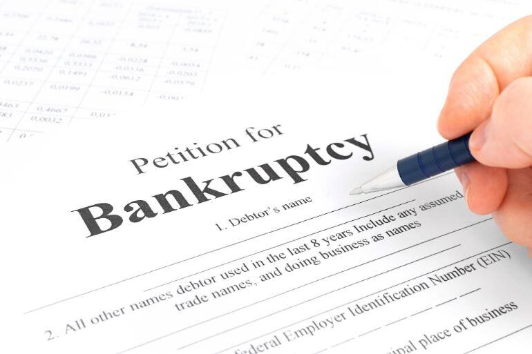 Person filling out bankruptcy petition paperwork