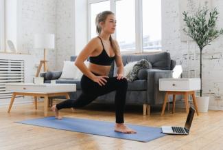 Person performing a yoga pose on a mat in their living room