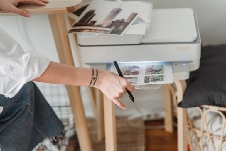 Person printing off photos in a home office