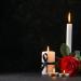 Burning candles and a red rose