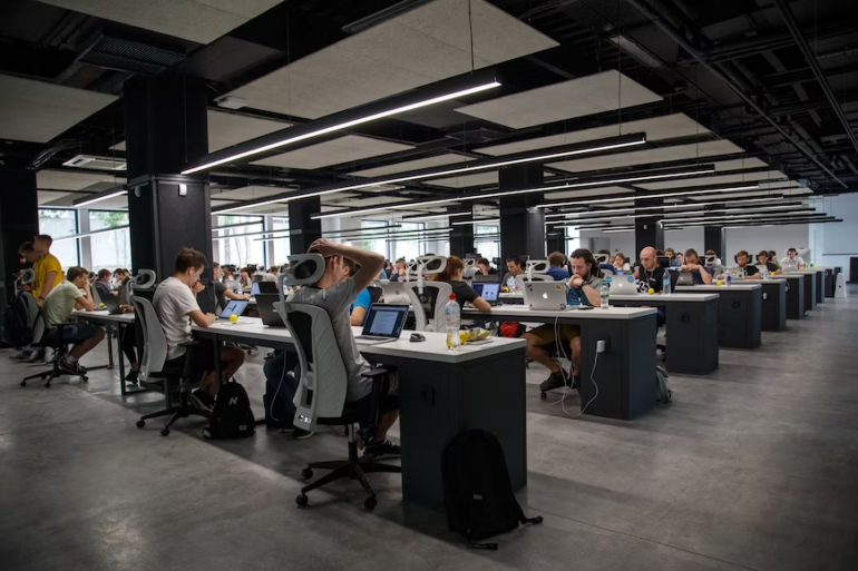 A group of people working in a large open plan office