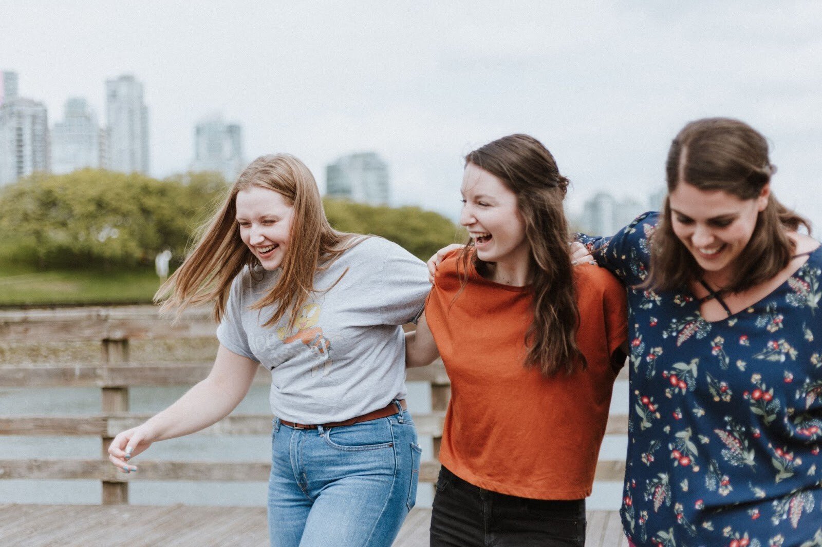 A group of young women smiling with their arms linked
