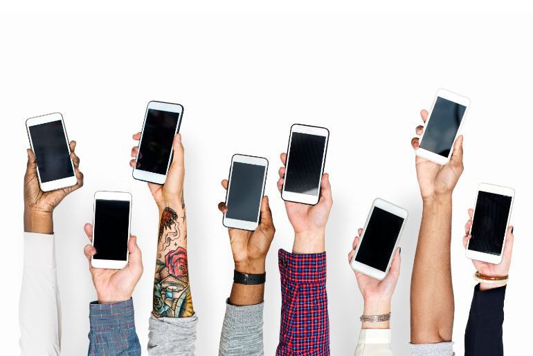 People holding up mobile phones in the air against a white background